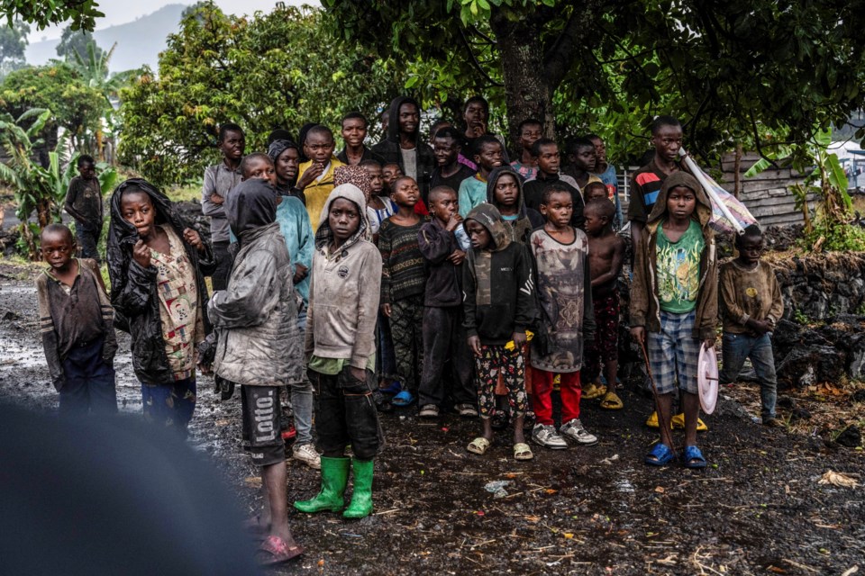 Congolese children watch the deployment of government and UN troops outside Goma, Democratic Republic of the Congo, Friday, Jan. 24, 2025, as M23 rebels are reported to close in on the town. (AP Photo/Moses Sawasawa)