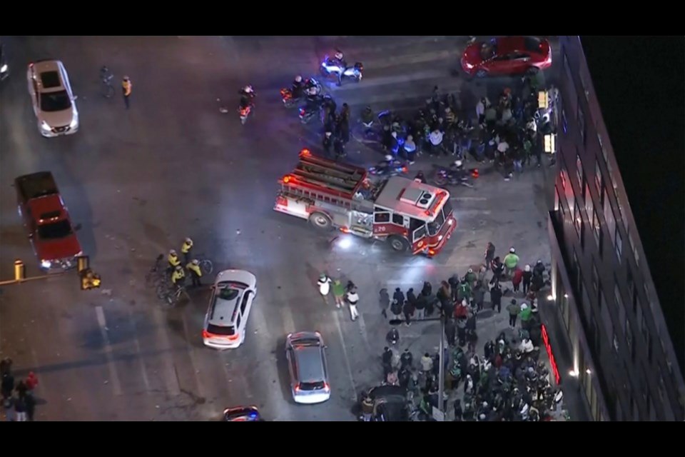 In this image from a video, first responders work near the scene after a car, police said, hit and injured pedestrians in a crowd of people that was leaving the Philadelphia Eagles playoff game, as bystanders gather on a street in Philadelphia Sunday, Jan. 26, 2025. (WPVI-TV/6ABC via AP)