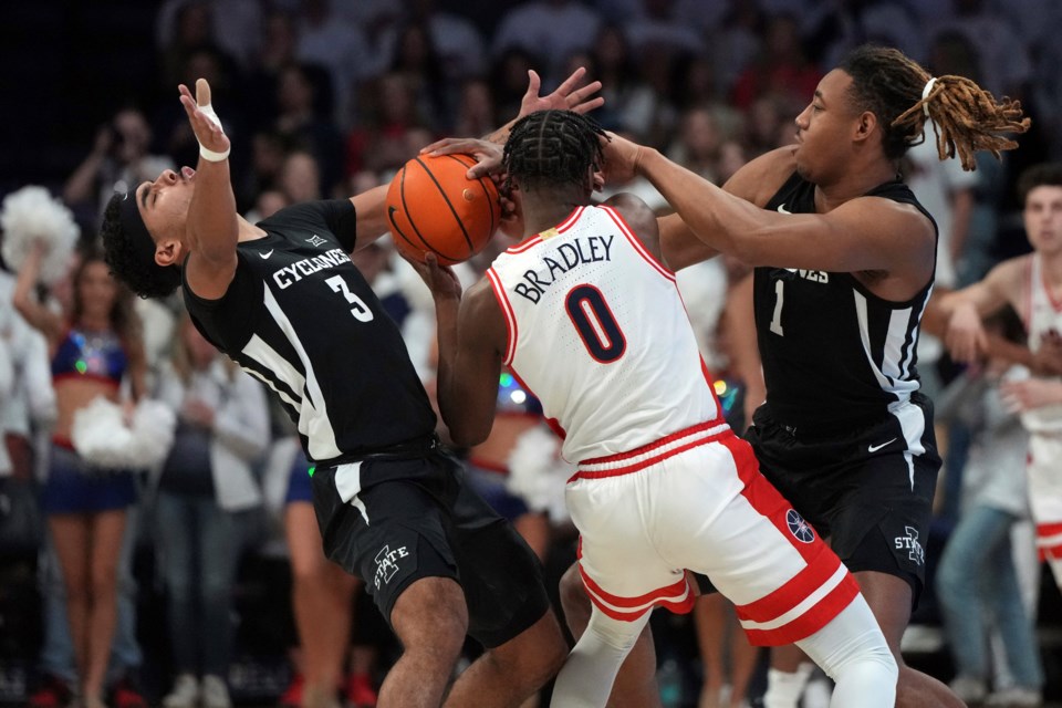 Iowa State guard Tamin Lipsey (3) and center Dishon Jackson (1) pressure Arizona guard Jaden Bradley (0) during the first half of an NCAA college basketball game, Monday, Jan. 27, 2025, in Tucson, Ariz. (AP Photo/Rick Scuteri)