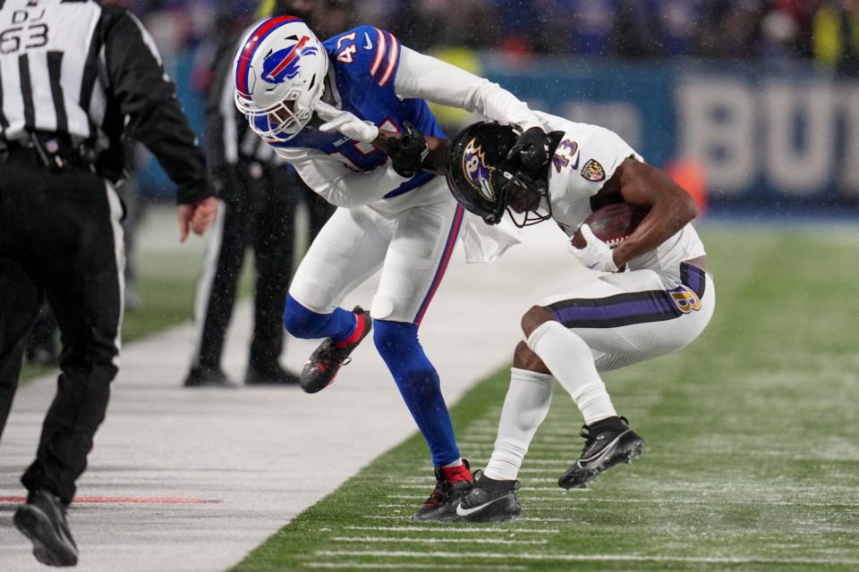 Baltimore Ravens running back Justice Hill (43) tries to avoid a tackle by Buffalo Bills cornerback Christian Benford (47) during the second quarter of an NFL divisional playoff football game, Sunday, Jan. 19, 2025, in Orchard Park, N.Y. (AP Photo/Gene J. Puskar)