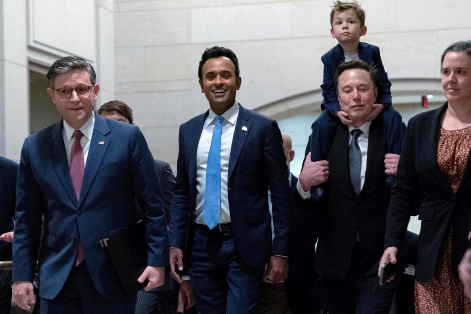 FILE - Speaker of the House Mike Johnson, R-La., from left, walks with Vivek Ramaswamy and Elon Musk, who is carrying his son X Æ A-Xii, as they walk to a meeting to discuss President-elect Donald Trump's planned Department of Government Efficiency, on Capitol Hill in Washington, Dec. 5, 2024. (AP Photo/Jose Luis Magana, File)