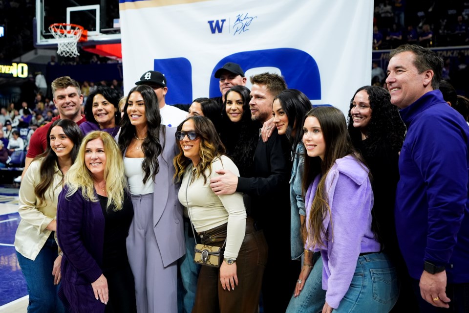 Former Washington player and current Las Vegas Aces guard Kelsey Plum poses for photos with friends and family during her jersey retirement ceremony during halftime of an NCAA college basketball game between Washington and Purdue, Saturday, Jan. 18, 2025, in Seattle. (AP Photo/Lindsey Wasson)