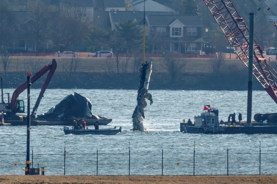 A piece of wreckage is lifted from the water onto a salvage vessel near the site in the Potomac River of a mid-air collision between an American Airlines jet and a Black Hawk helicopter, at Ronald Reagan Washington National Airport, Tuesday, Feb. 4, 2025, in Arlington, Va. (AP Photo/Ben Curtis)