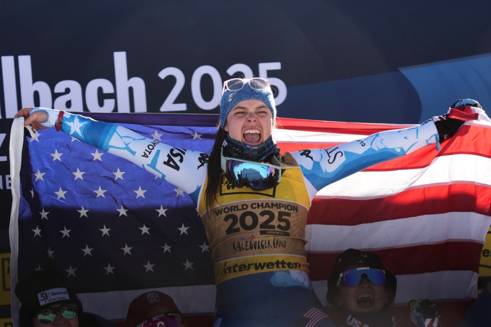 United States' Breezy Johnson celebrates on the podium after winning the gold medal in a women's downhill race, at the Alpine Ski World Championships, in Saalbach-Hinterglemm, Austria, Saturday, Feb. 8, 2025. (AP Photo/Giovanni Auletta)