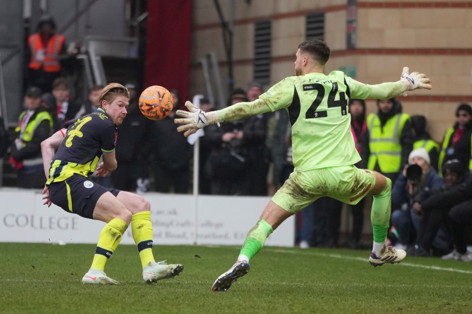 Manchester City's Kevin De Bruyne, left, scores his side's second goal during the English FA Cup fourth round soccer match between Leyton Orient and Manchester City at the Gaughan Group Stadium in London, England, Saturday, Feb. 8, 2025. (AP Photo/Kin Cheung)