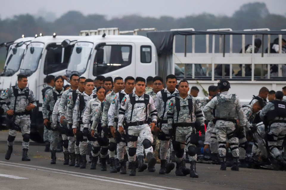 Mexican National Guards prepare to board an aircraft at the International Airport in Merida, Mexico, Tuesday, Feb. 4, 2025, to travel north to reinforce the country's border with the United States. (AP Photo/Martin Zetina)