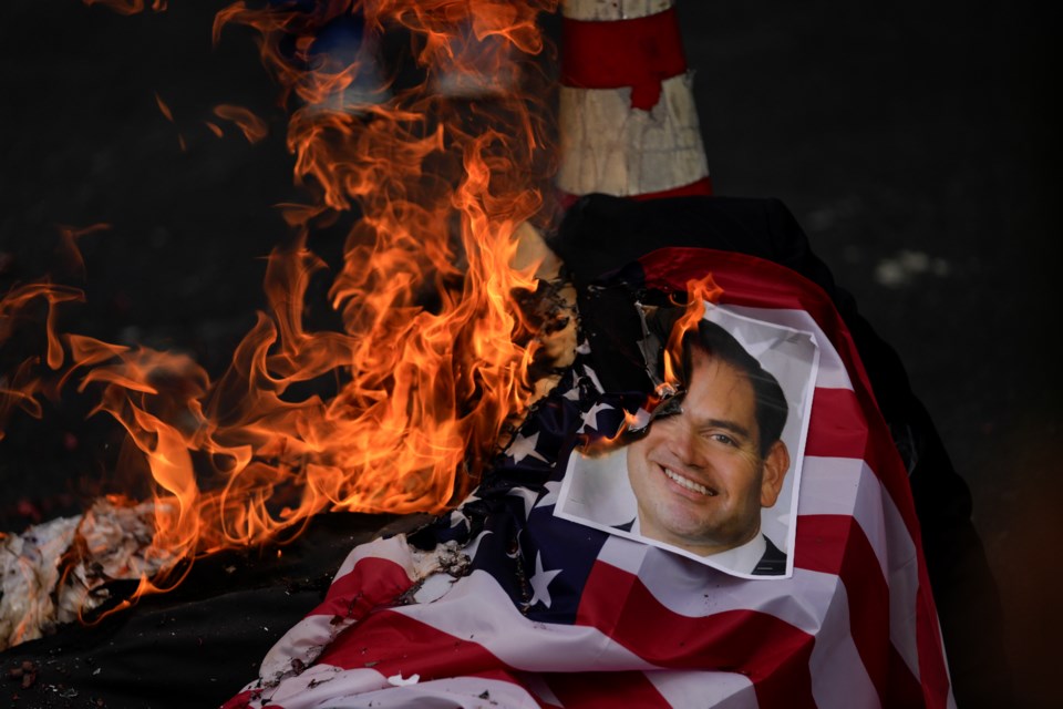 A photo of U.S. Secretary of State Marco Rubio is burned by demonstrators protesting his upcoming visit to Panama City, Friday, Jan. 31, 2025. (AP Photo/Matias Delacroix)