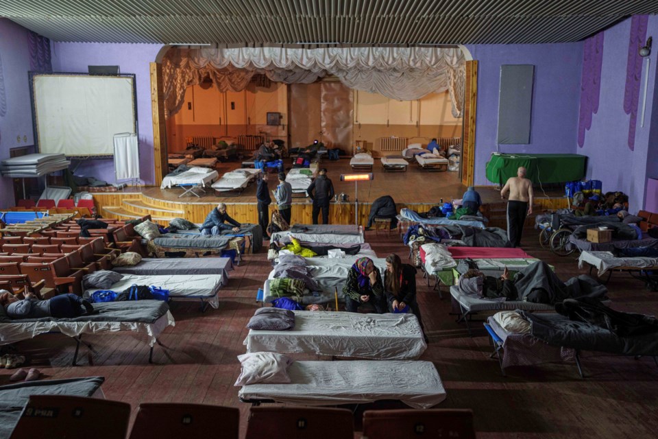 People sit on beds after evacuation from the frontline at a center for displaced people in Pavlohrad, Ukraine, Saturday, Feb. 1, 2024. (AP Photo/Evgeniy Maloletka)Maloletka)