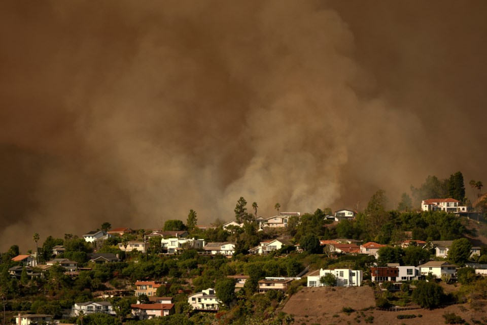 FILE - Smoke from the Palisades Fire rises over residences in Mandeville Canyon Saturday, Jan. 11, 2025, in Los Angeles. (AP Photo/Jae C. Hong, File)