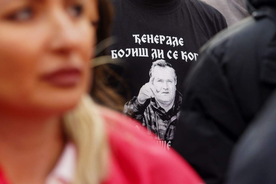 A man wearing a T-shirt with a picture of former Bosnian Serb wartime general Ratko Mladic reading: "General, are you afraid of anyone?"attends a rally on the eve of a scheduled court verdict that could order the pro-Russia Serb leader Milorad Dodik banned from politics or even sentenced to prison in the Bosnian town of Banja Luka, 240 kms northwest of Sarajevo, Tuesday, Feb. 25, 2025. (AP Photo/Radivoje Pavicic)