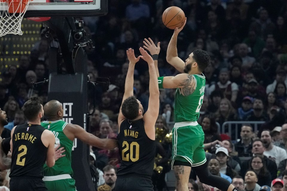 Boston Celtics forward Jayson Tatum, right, shoots in front of Cleveland Cavaliers forward Georges Niang (20) in the first half of an NBA basketball game, Tuesday, Feb. 4, 2025, in Cleveland. (AP Photo/Sue Ogrocki)