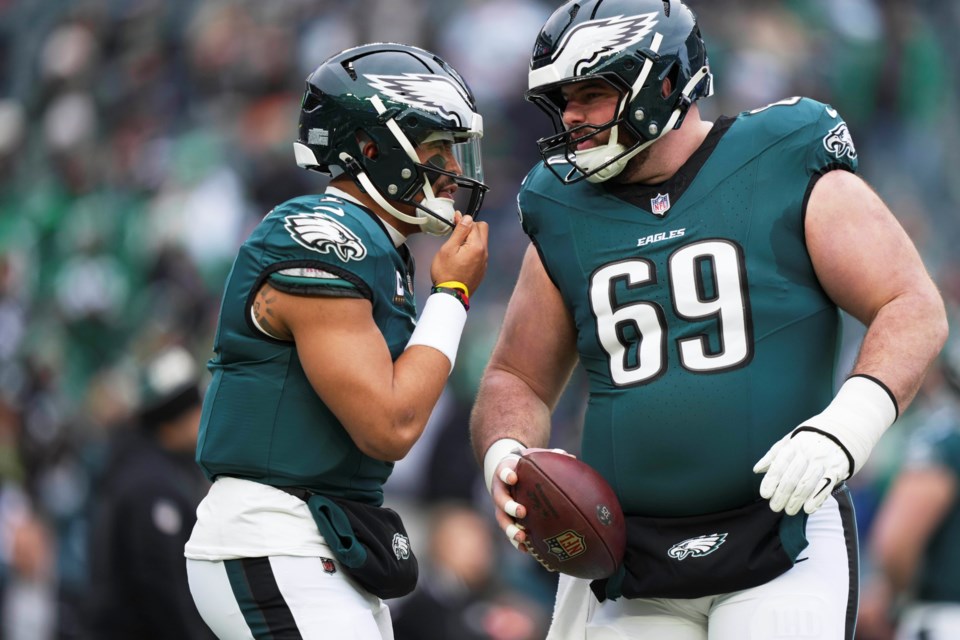 Philadelphia Eagles quarterback Jalen Hurts, left, talks to Landon Dickerson (69) during warm ups before the NFC Championship NFL football game against the Washington Commanders, Sunday, Jan. 26, 2025, in Philadelphia. (AP Photo/Matt Slocum)