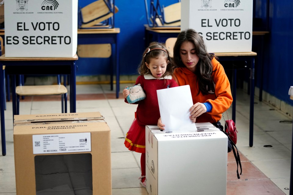 A voter casts her ballot in the presidential election in Quito, Ecuador, Sunday, Feb. 9, 2025. (AP Photo/Dolores Ochoa)