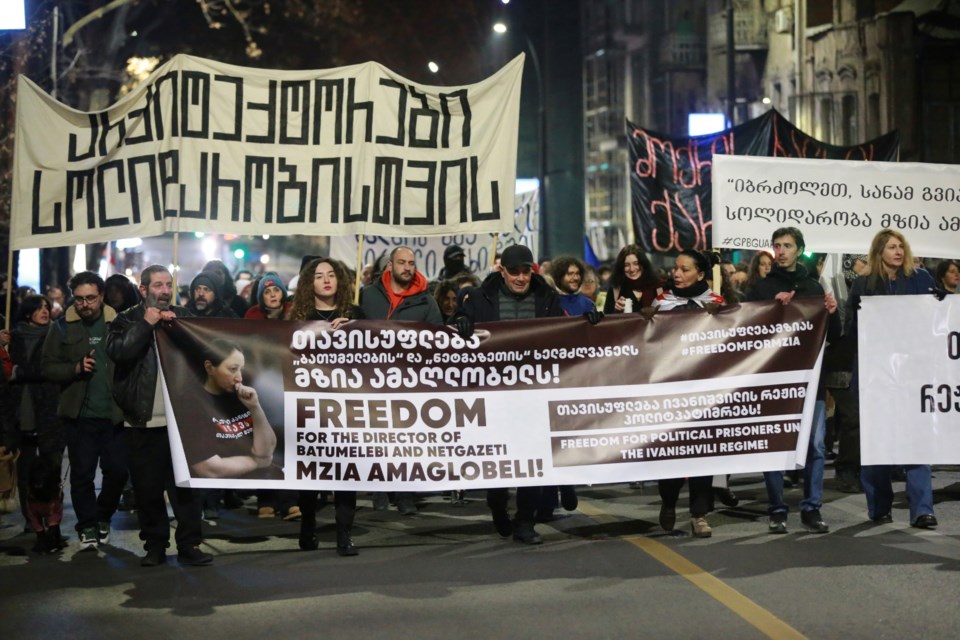 Protesters hold banners calling for the release of jailed journalist Mzia Amaghlobeli as they march through the streets in Tbilisi, Georgia, on Wednesday, Jan. 29, 2025. (AP Photo/Zurab Tsertsvadze)