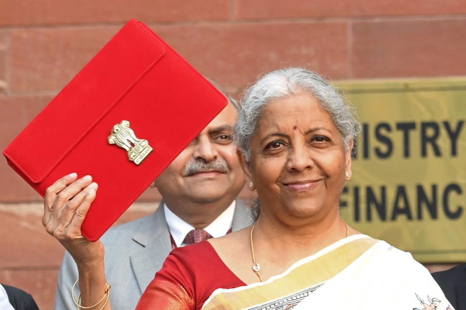 Indian Finance Minister Nirmala Sitharaman shows a red pouch containing budget documents, as she arrives to present the federal budget in the Parliament in New Delhi, India, Saturday, Feb. 1, 2025. (AP Photo)