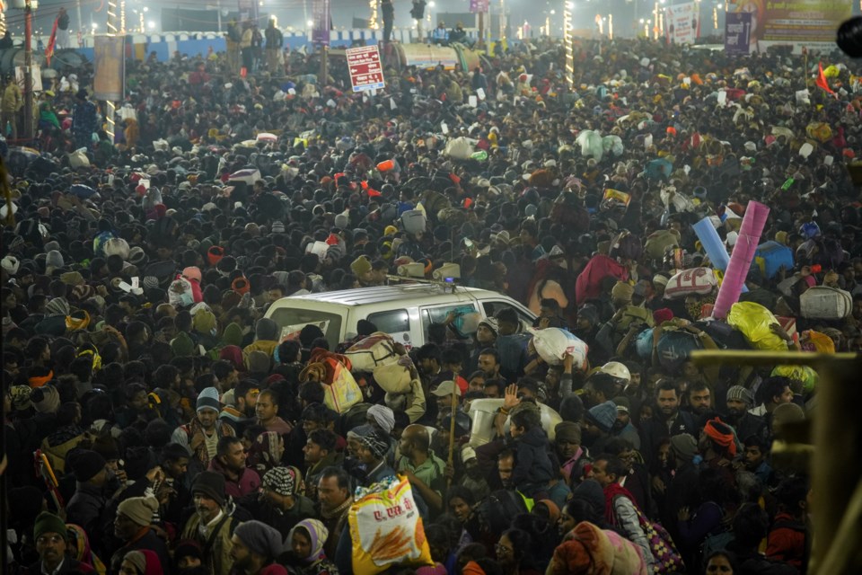 An ambulance moves in the middle of a crowd of Hindu devotees gathered for a holy dip by the banks of the Sangam, the confluence of the Ganges, the Yamuna and the mythical Saraswati rivers, on Mauni Amavasya' or new moon day during the Maha Kumbh festival in Prayagraj, Uttar Pradesh, India, Wednesay, Jan. 29, 2025. (AP Photo/Deepak Sharma)