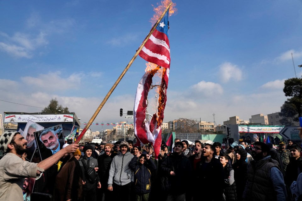 Iranian demonstrators burn a representation of the U.S. flag during a rally commemorating anniversary of 1979 Islamic Revolution that toppled the late pro-U.S. Shah Mohammad Reza Pahlavi and brought Islamic clerics to power, in Tehran, Iran, Monday, Feb. 10, 2025. (AP Photo/Vahid Salemi)