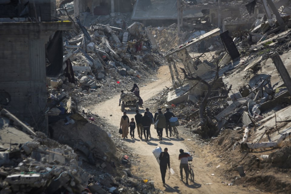 Palestinians who have returned walk among the rubble of buildings largely destroyed by Israeli army bombardments in Beit Lahia, northern Gaza Strip, Wednesday, Jan. 29, 2025, after Israel began allowing hundreds of thousands of Palestinians to return to the heavily damaged area last Monday.(AP Photo/Jehad Alshrafi)