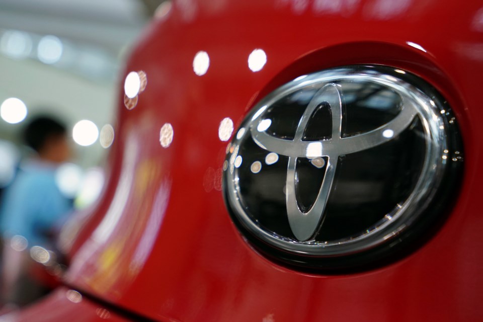 FILE - People walk by the logo of Toyota at a show room in Tokyo, Aug. 2, 2019. (AP Photo/Eugene Hoshiko, File)