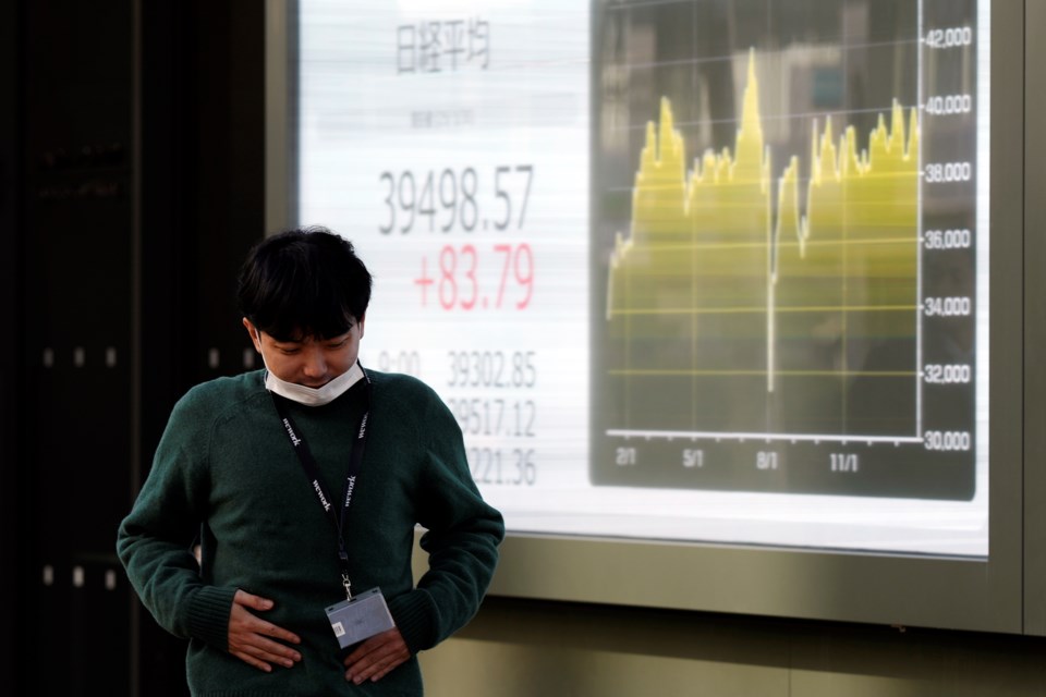 A person walks in front of an electronic stock board showing Japan's Nikkei index at a securities firm Thursday, Jan. 30, 2025, in Tokyo. (AP Photo/Eugene Hoshiko)