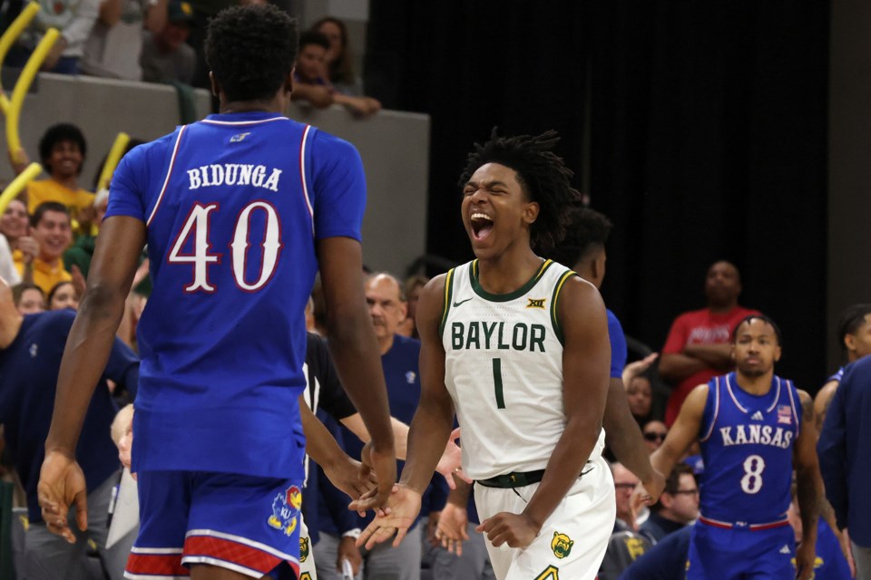 Baylor guard Robert Wright III celebrates after scoring as Kansas forward Flory Bidunga walks back to the bench while his teammate, guard David Coit, looks on during the second half of an NCAA college basketball game Saturday, Feb. 1, 2025, in Waco, Texas. (AP Photo/Jerry Larson)