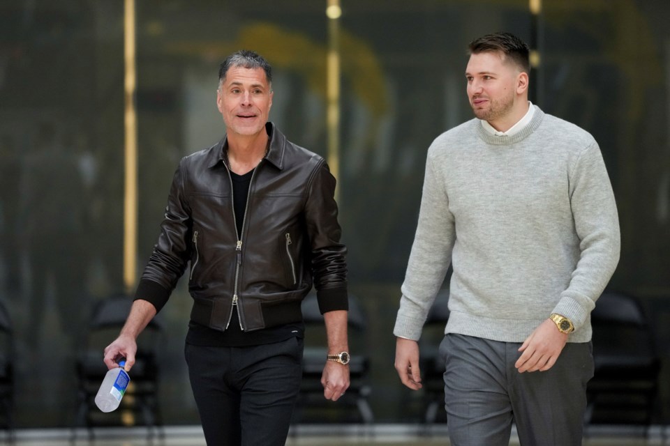 Los Angeles Lakers' Luka Doncic, right, walks to the podium with general manger Rob Pelinka during an introductory NBA basketball press conference Tuesday, Feb. 4, 2025, in El Segundo, Calif. (AP Photo/Jae C. Hong)