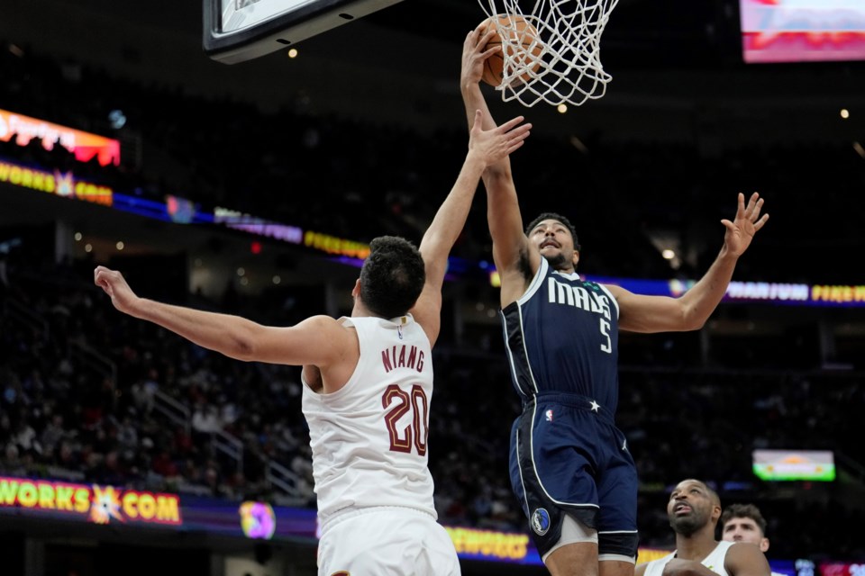 Dallas Mavericks guard Quentin Grimes (5) shoots over Cleveland Cavaliers forward Georges Niang (20) in the second half of an NBA basketball game, Sunday, Feb. 2, 2025, in Cleveland. (AP Photo/Sue Ogrocki)