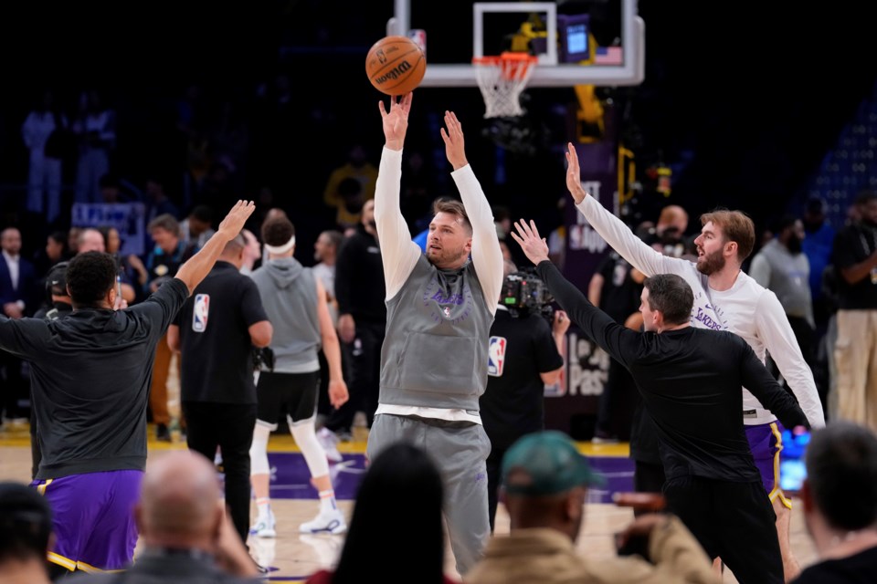 Los Angeles Lakers guard Luka Doncic, center, warms up before an NBA basketball game against the Dallas Mavericks, Tuesday, Feb. 25, 2025, in Los Angeles. (AP Photo/Mark J. Terrill)