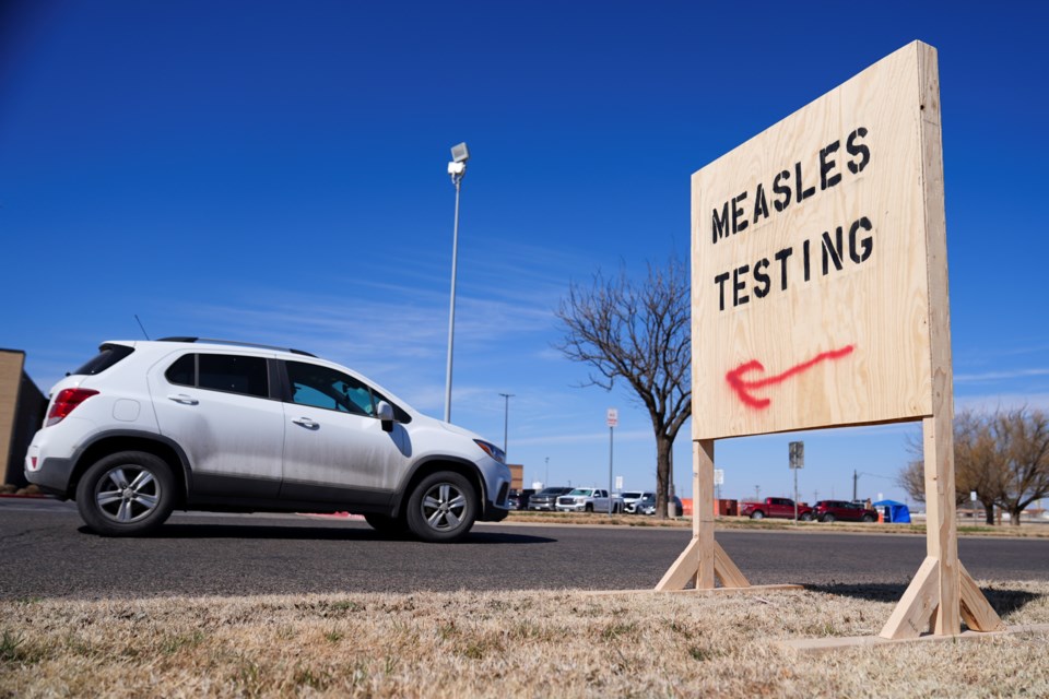 A vehicle drives past a sign outside of Seminole Hospital District offering measles testing Friday, Feb. 21, 2025, in Seminole, Texas. (AP Photo/Julio Cortez)