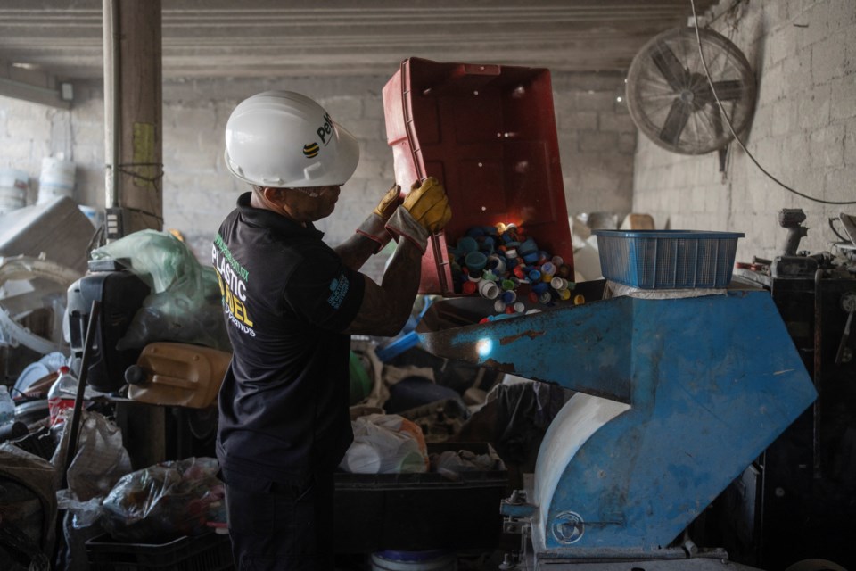 Jesus Cuevas, a Petgas technician, puts plastic caps into a shredding machine inside a recycling center in Boca del Rio, Veracruz, Mexico, Jan. 4, 2025. (AP Photo/Felix Marquez)