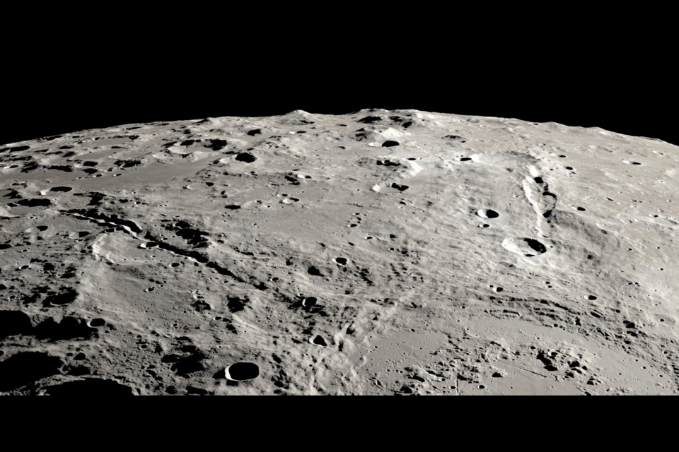 This image provided by NASA shows a view from orbit looking obliquely across the surface of the moon, where an ancient asteroid strike carved out a pair of grand canyons on the moon’s far side. (Ernie T. Wright/NASA via AP)