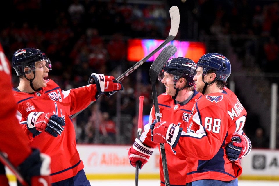 Washington Capitals left wing Andrew Mangiapane (88) celebrates his goal with defensemen John Carlson, right, and Rasmus Sandin, second from left, during the first period of an NHL hockey game against the Florida Panthers, Tuesday, Feb. 4, 2025, in Washington. (AP Photo/Nick Wass)