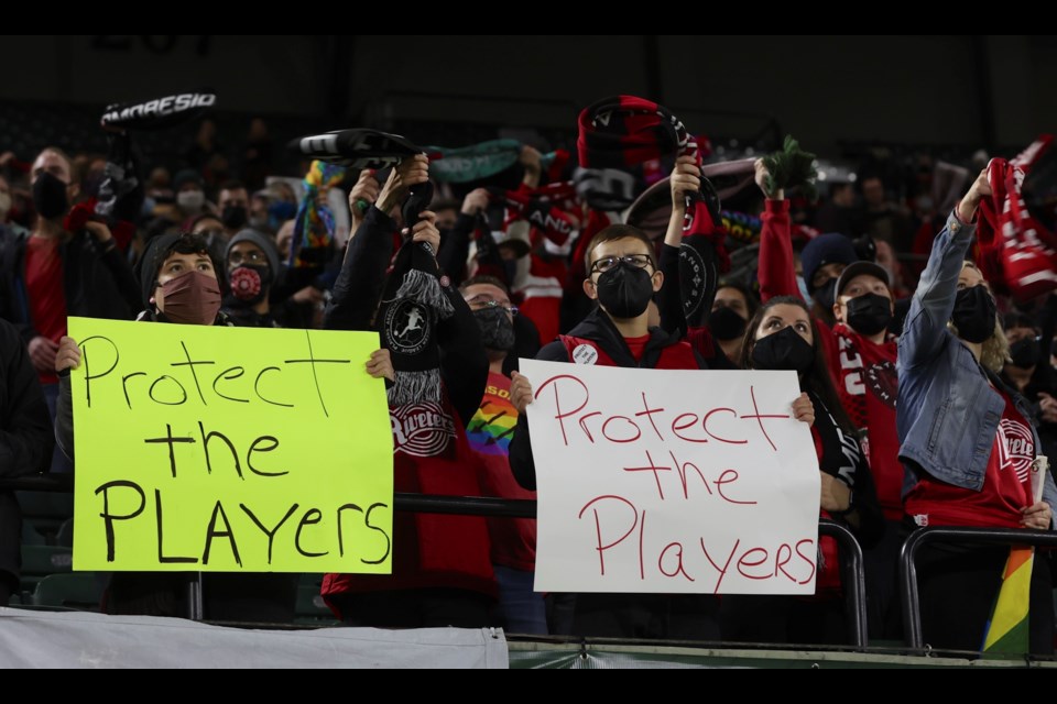 FILE - Portland Thorns fans hold signs during the first half of the team's NWSL soccer match against the Houston Dash in Portland, Ore., Oct. 6, 2021. (AP Photo/Steve Dipaola, File)