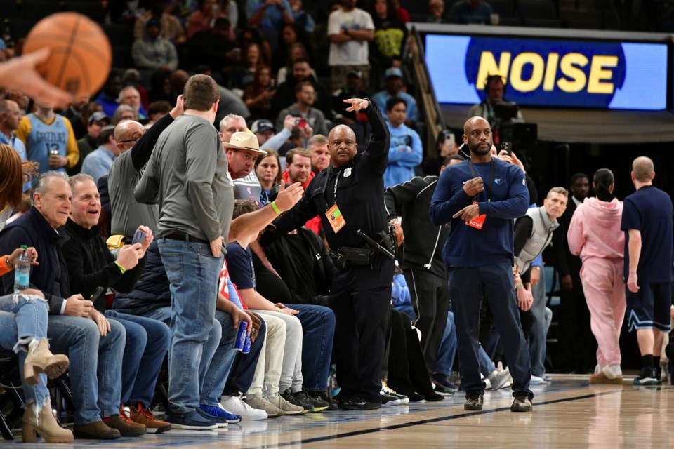 A police officer motions for help as a man has a medical emergency before an NBA basketball game between the San Antonio Spurs and the Memphis Grizzlies Monday, Feb. 3, 2025, in Memphis, Tenn. (AP Photo/Brandon Dill)