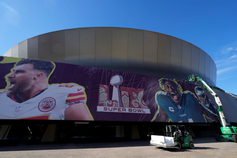 Workers hang player banners outside the Caesars Superdome, Saturday, Feb. 1, 2025, in New Orleans, prior to the NFL Super Bowl 59 football game between the Philadelphia Eagles and the Kansas City Chiefs. (AP Photo/Godofredo A. Vásquez)