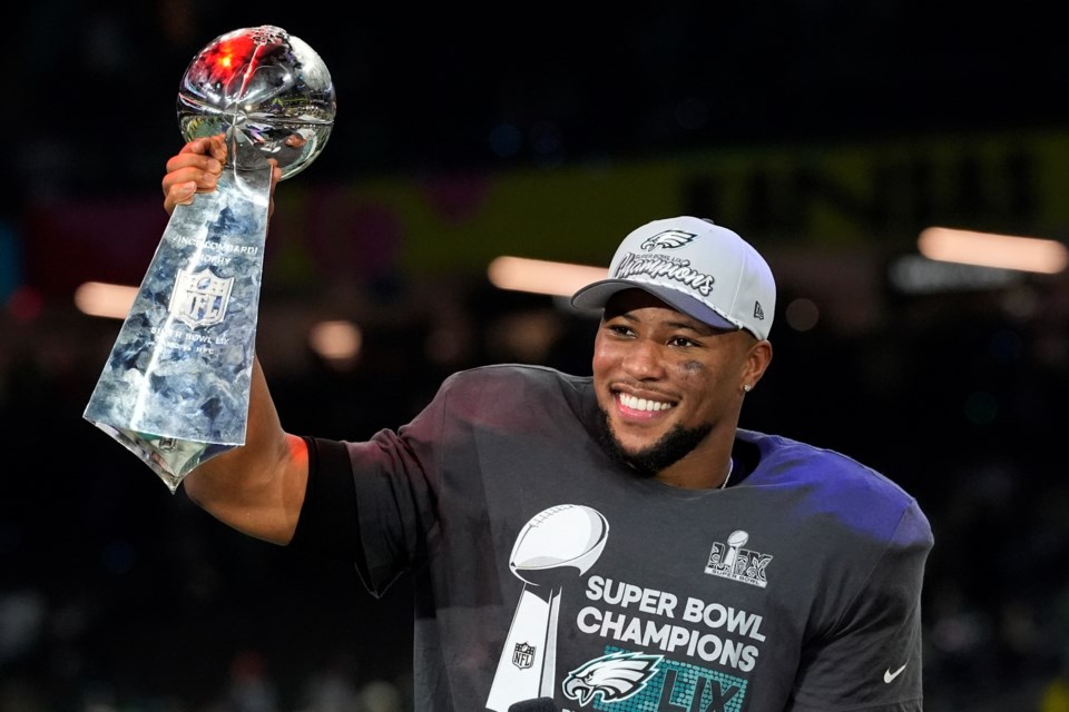 Philadelphia Eagles running back Saquon Barkley celebrates with the Vince Lombardi Trophy after the NFL Super Bowl 59 football game against the Kansas City Chiefs, Sunday, Feb. 9, 2025, in New Orleans. (AP Photo/Brynn Anderson)