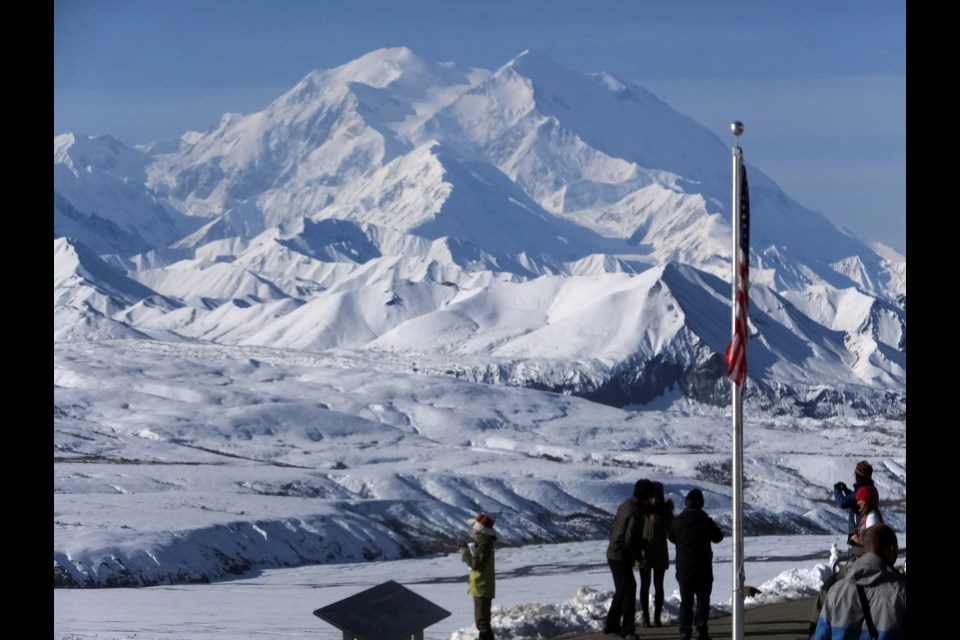 FILE - People stand at the Eielson Visitor Center with a view of North America's tallest peak, Denali, in the background, Sept. 2, 2015, in Denali National Park and Preserve, Alaska. (AP Photo/Becky Bohrer, file)