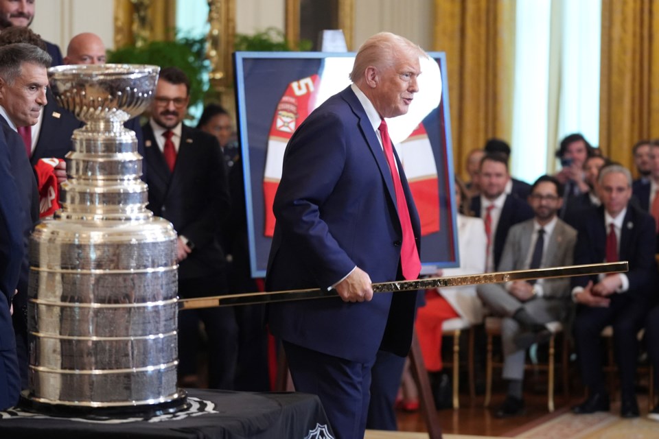 President Donald Trump holds a gold hockey stick present to him by the the 2024 NHL Stanley Cup champion Florida Panthers hockey team during a ceremony in the East Room of the White House, Monday, Feb. 3, 2025, in Washington. (AP Photo/Evan Vucci)