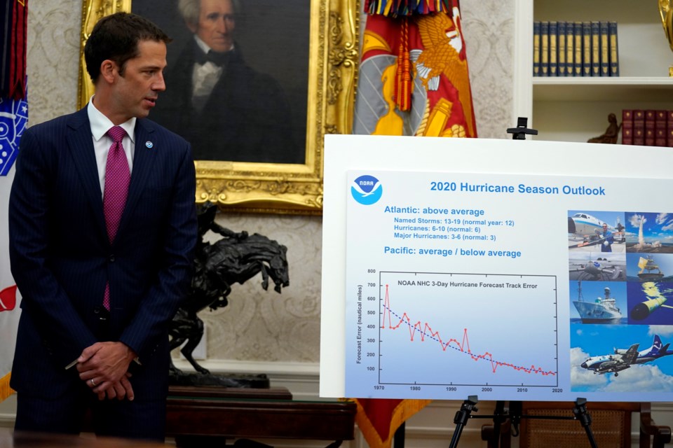 FILE - Neil Jacobs, assistant Secretary of Commerce for Environmental Observation and Prediction, stands next to a chart during a briefing with President Donald Trump on the 2020 hurricane season in the Oval Office of the White House in Washington on May 28, 2020. (AP Photo/Evan Vucci, File)