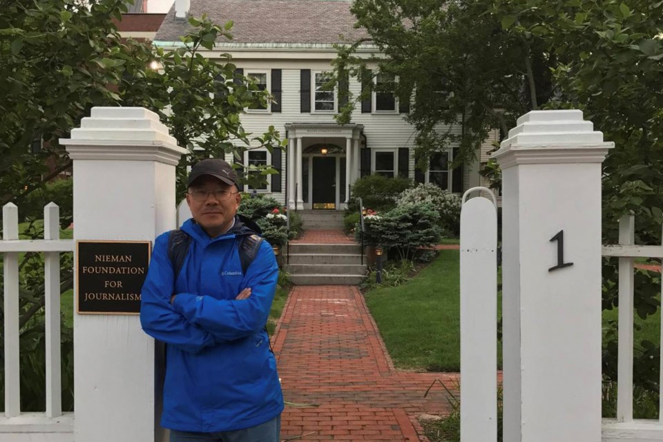 In this photo provided by the Dong family, Chinese journalist Dong Yuyu stands at the gates of the Nieman Foundation for Journalism at Harvard University in Cambridge, Mass., in May 2017. (Dong Family via AP)