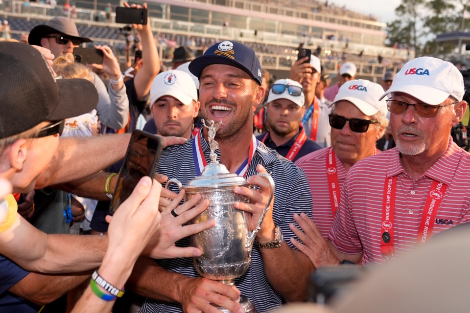 FILE - Bryson DeChambeau celebrates with fans and the trophy after winning the U.S. Open golf tournament Sunday, June 16, 2024, in Pinehurst, N.C. (AP Photo/Frank Franklin II, File)