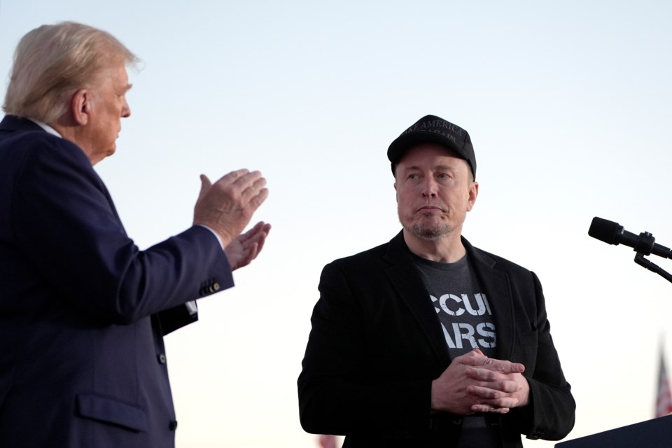 FILE - Republican presidential nominee former President Donald Trump, left, claps as Tesla and SpaceX CEO Elon Musk prepares to depart after speaking at a campaign event at the Butler Farm Show, on Oct. 5, 2024, in Butler, Pa. (AP Photo/Alex Brandon, File)