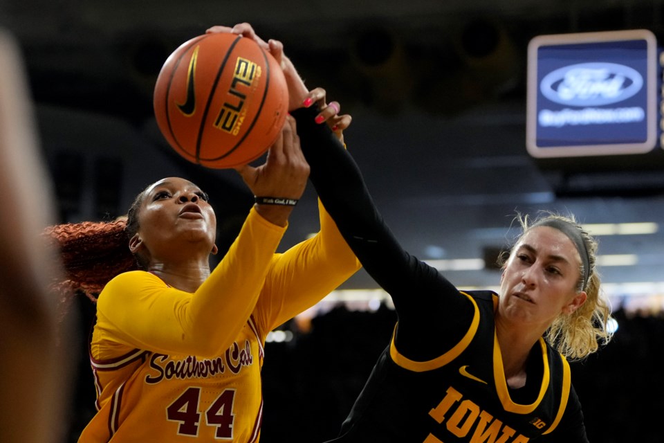 Southern California forward Kiki Iriafen (44) fights for a rebound with Iowa guard Lucy Olsen, right, during the first half of an NCAA college basketball game, Sunday, Feb. 2, 2025, in Iowa City, Iowa. (AP Photo/Charlie Neibergall)