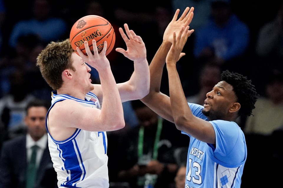 Duke guard Kon Knueppel shoots over North Carolina forward Jalen Washington during the first half of an NCAA college basketball game in the semifinals of the Atlantic Coast Conference tournament, Friday, March 14, 2025, in Charlotte, N.C. (AP Photo/Chris Carlson)