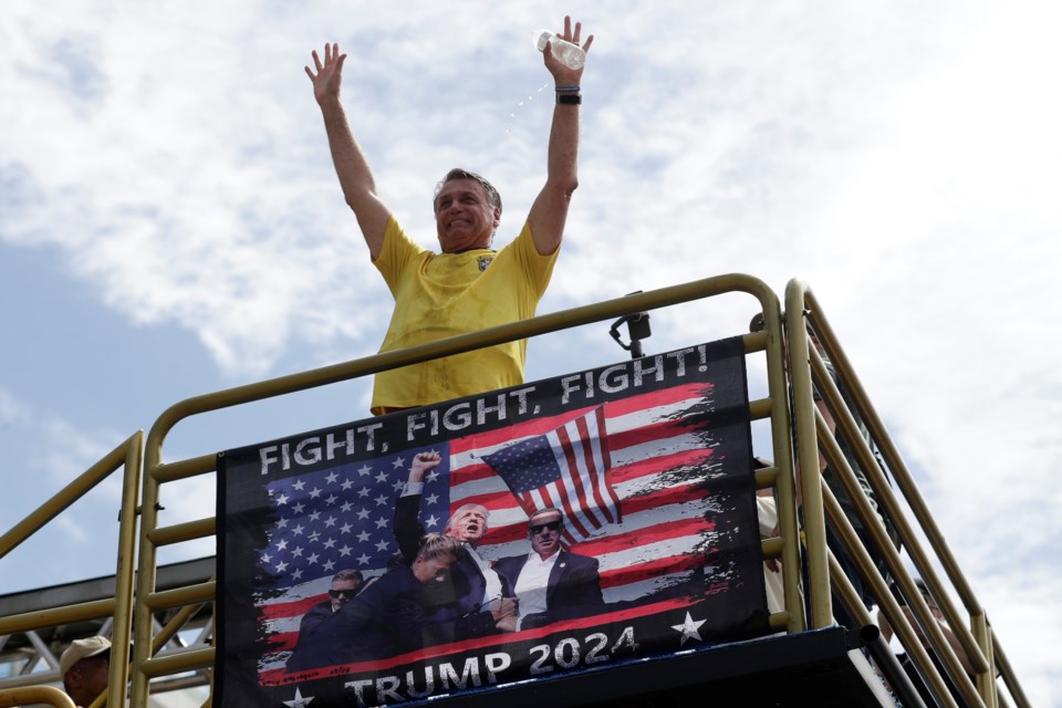 Brazil's former President Jair Bolsonaro gestures to the crowd upon arriving at a rally on Copacabana Beach in support of a proposed bill to grant amnesty to those arrested for storming government buildings in an alleged coup attempt in 2023, in Rio de Janeiro, Sunday, March 16, 2025. (AP Photo/Bruna Prado)