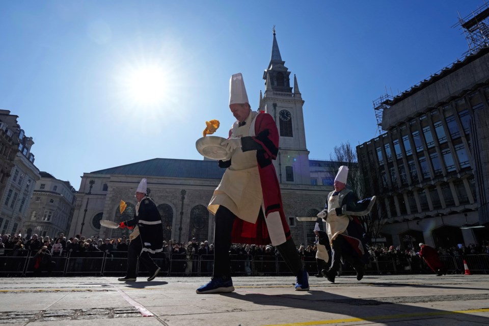 Runners compete during a traditional pancake race by livery companies at the Guildhall in London, Tuesday, March 4, 2025.(AP Photo/Frank Augstein)