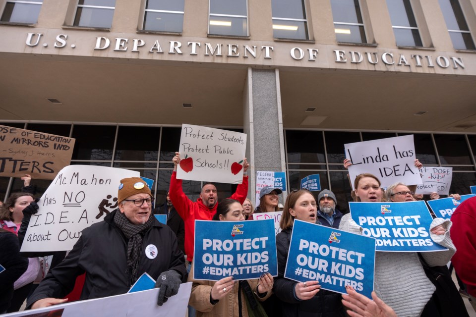 Protestors gather during a demonstration at the headquarters of the Department of Education, Friday, March 14, 2025, in Washington. (AP Photo/Mark Schiefelbein)