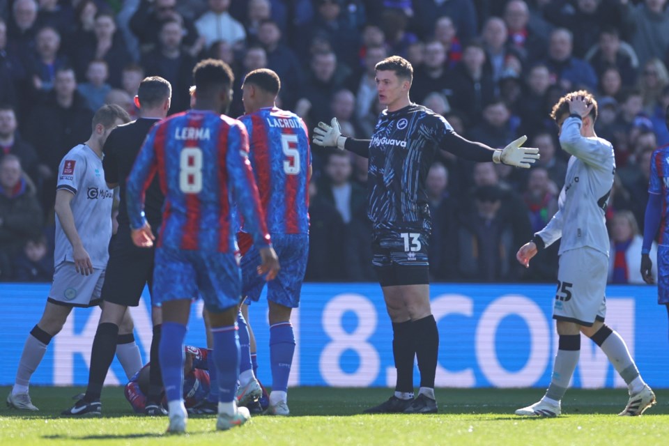 Millwall goalkeeper Liam Roberts reacts before getting a red card for a challenge of Crystal Palace's Jean-Philippe Mateta during the English FA Cup soccer match between Crystal Palace and Millwall at Selhurst Park, London, England, Saturday, March 1, 2025. (AP Photo/Ian Walton)