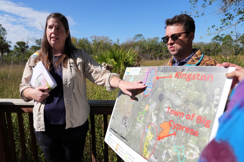 Amber Crooks, environmental policy manager with the Conservancy of Southwest Florida, left, and Michael McGrath of the Sierra Club, right, hold a map showing proposed developments at the Panther National Wildlife Refuge in Southwest Florida, Wednesday, Jan. 15, 2025. (AP Photo/Lynne Sladky)