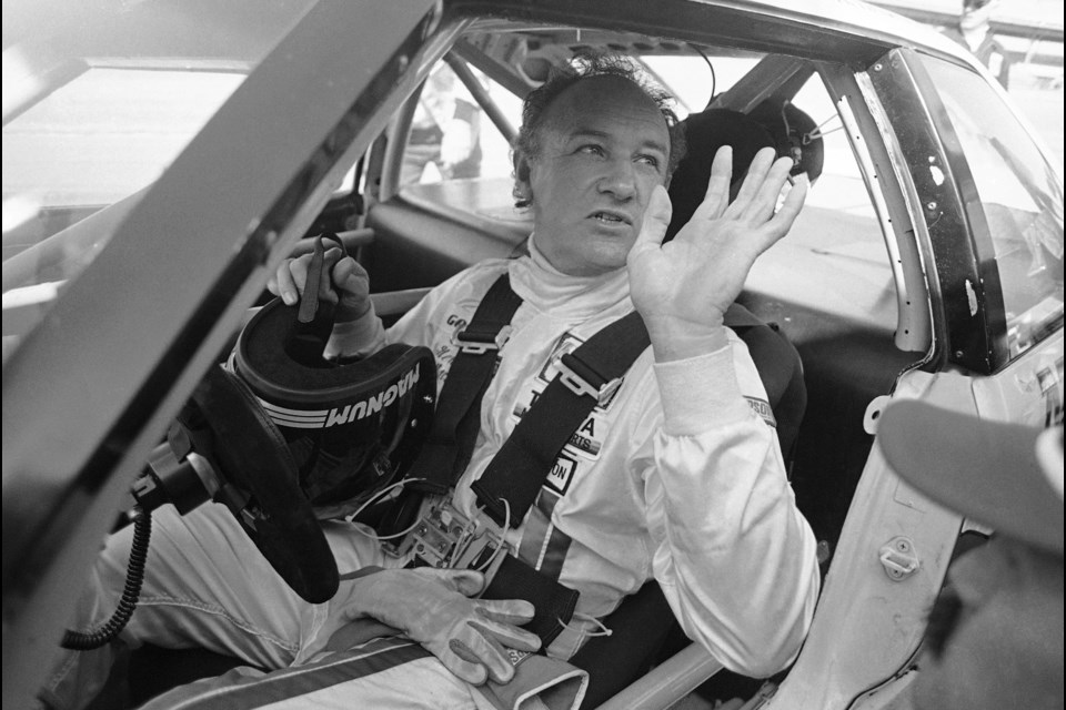 FILE - Actor Gene Hackman waves as he starts out for a practice run in his Toyota Celica, Feb. 5, 1983 at the Daytona International Speedway in preparation for the Daytona 24 Hour Endurac Race. This race marks the start of Hickman?s career as a professional driver. (AP Photo/Bob Self, File)